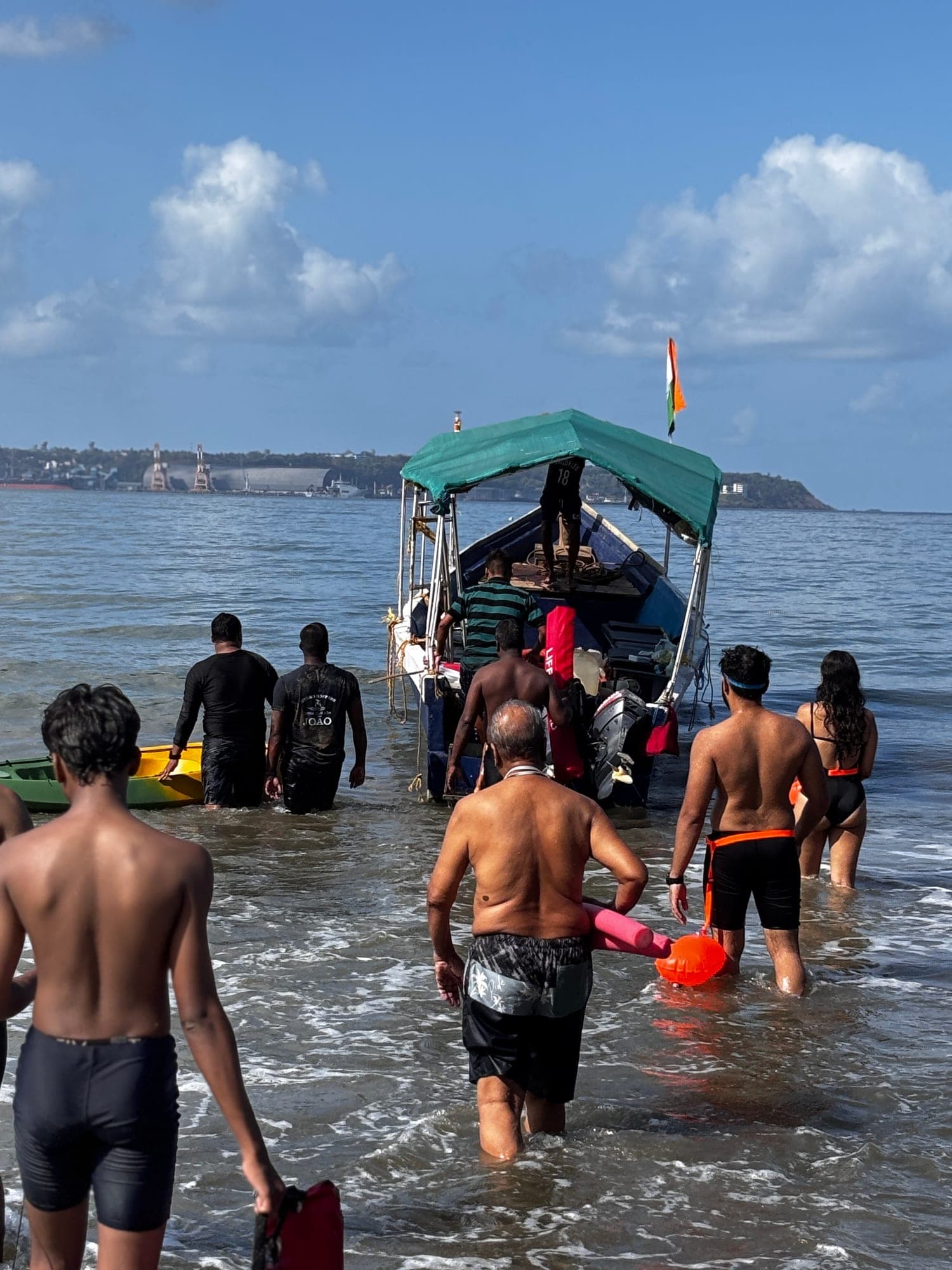 Swimmers wading out towards the safety boat with an Indian flag
