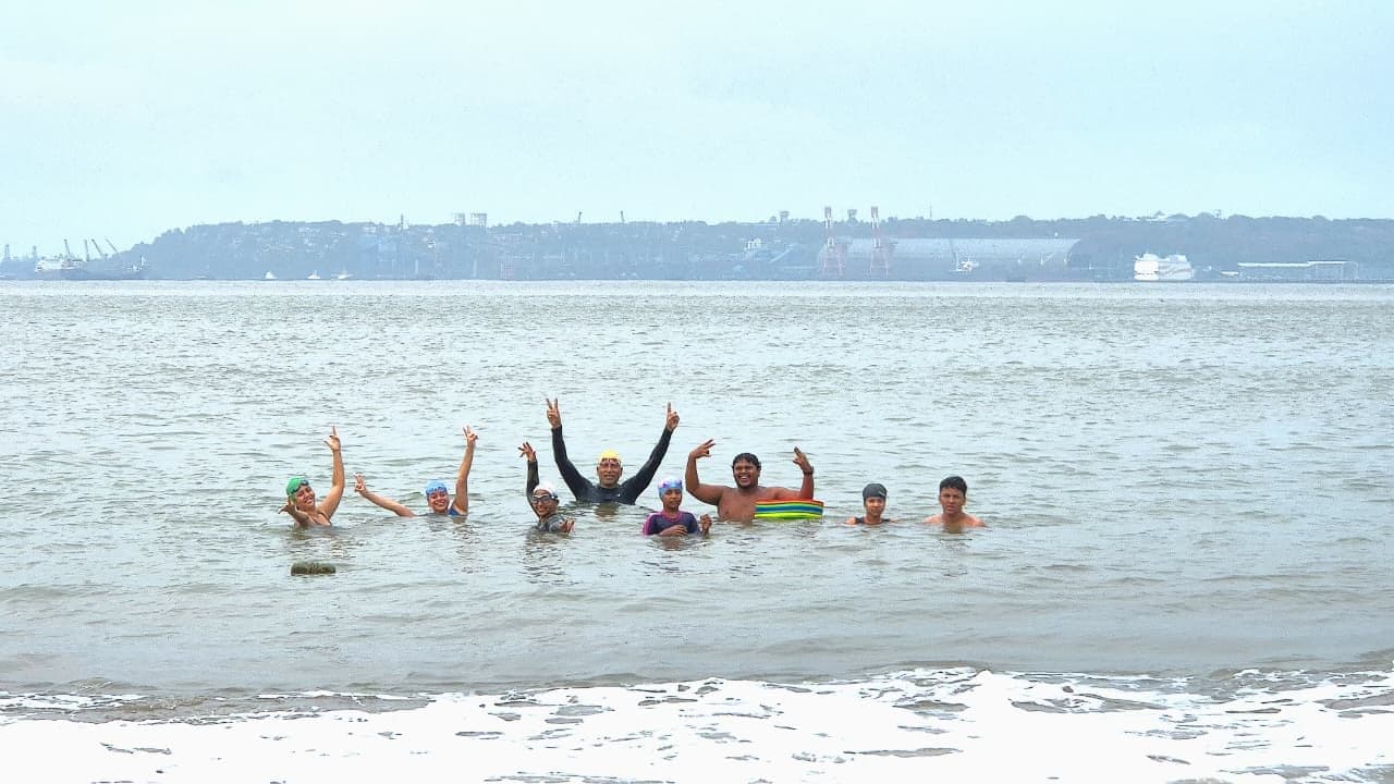 The whole group cheering with peace signs in the sea