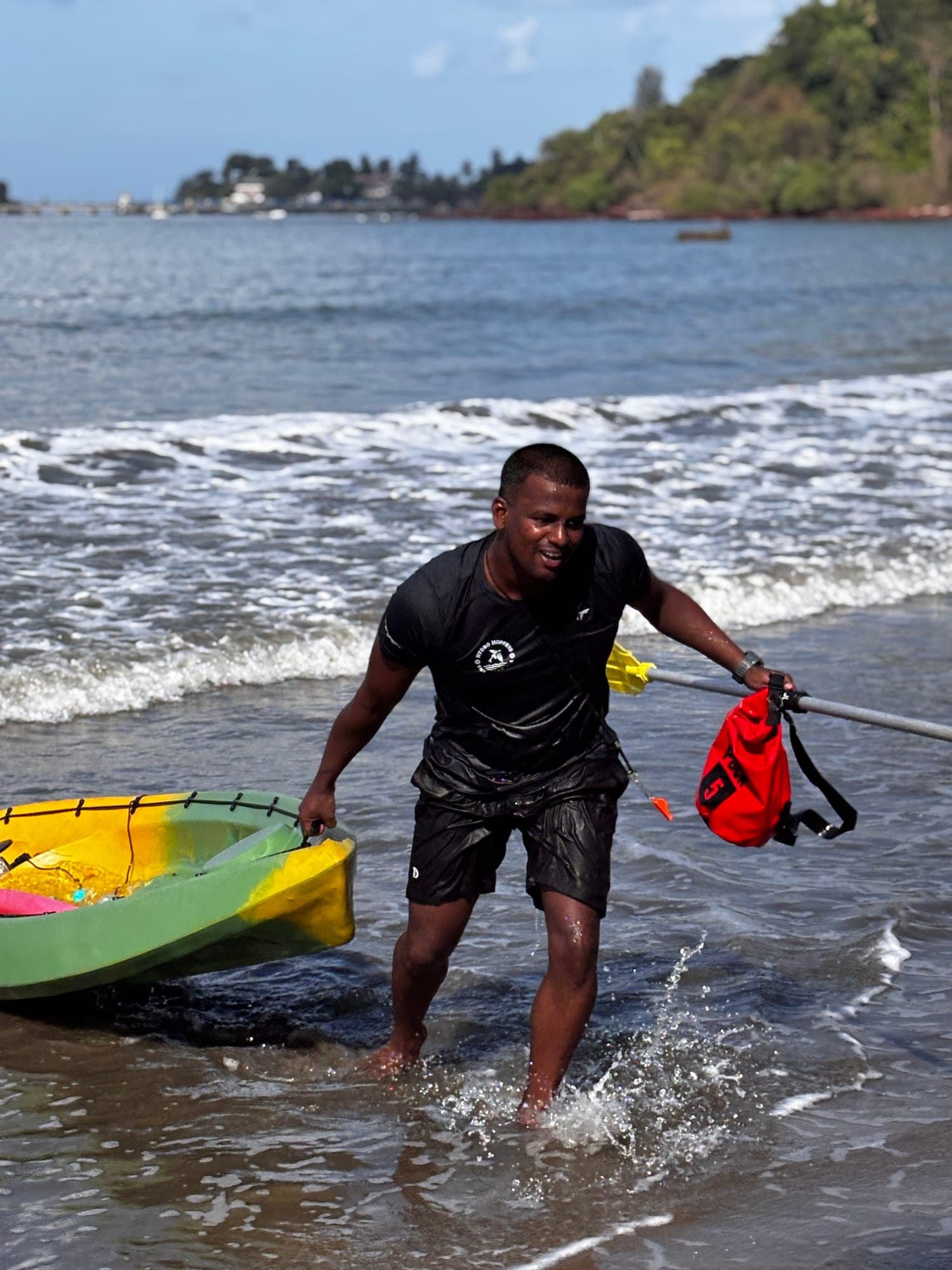 Hydro Hoppers coach hauling a kayak out of the sea at Dona Paula