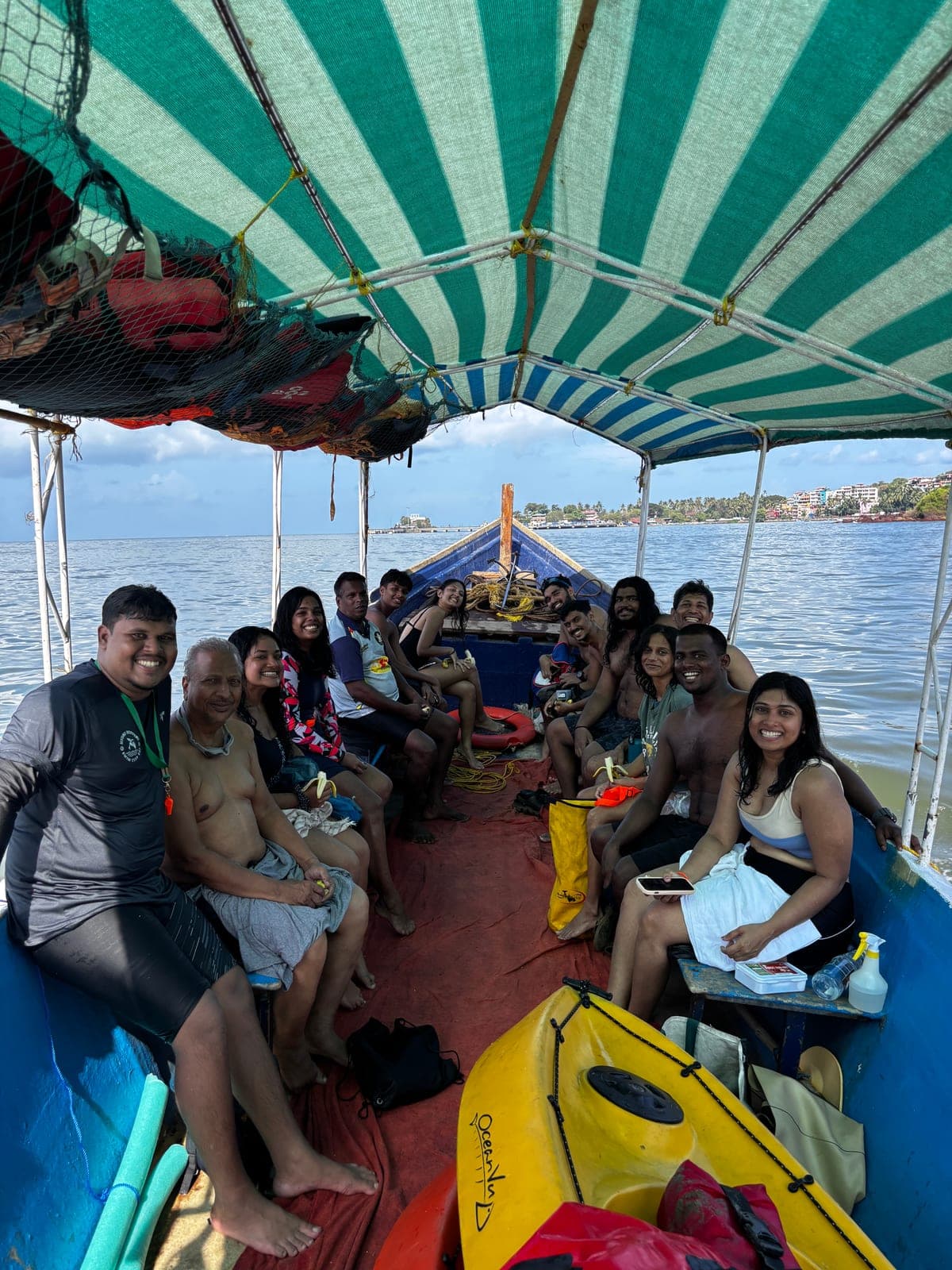 The whole group aboard the boat under a striped canopy