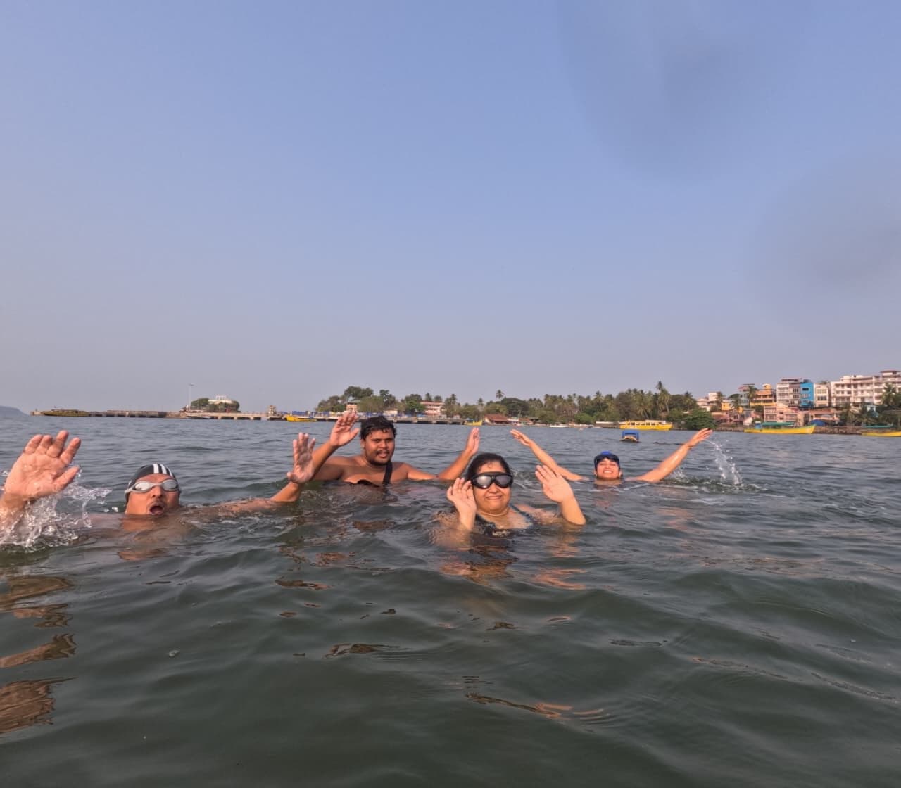 Group of swimmers waving and cheering together in the sea