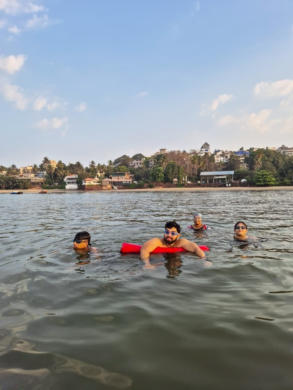Group of swimmers floating together with a pool noodle
