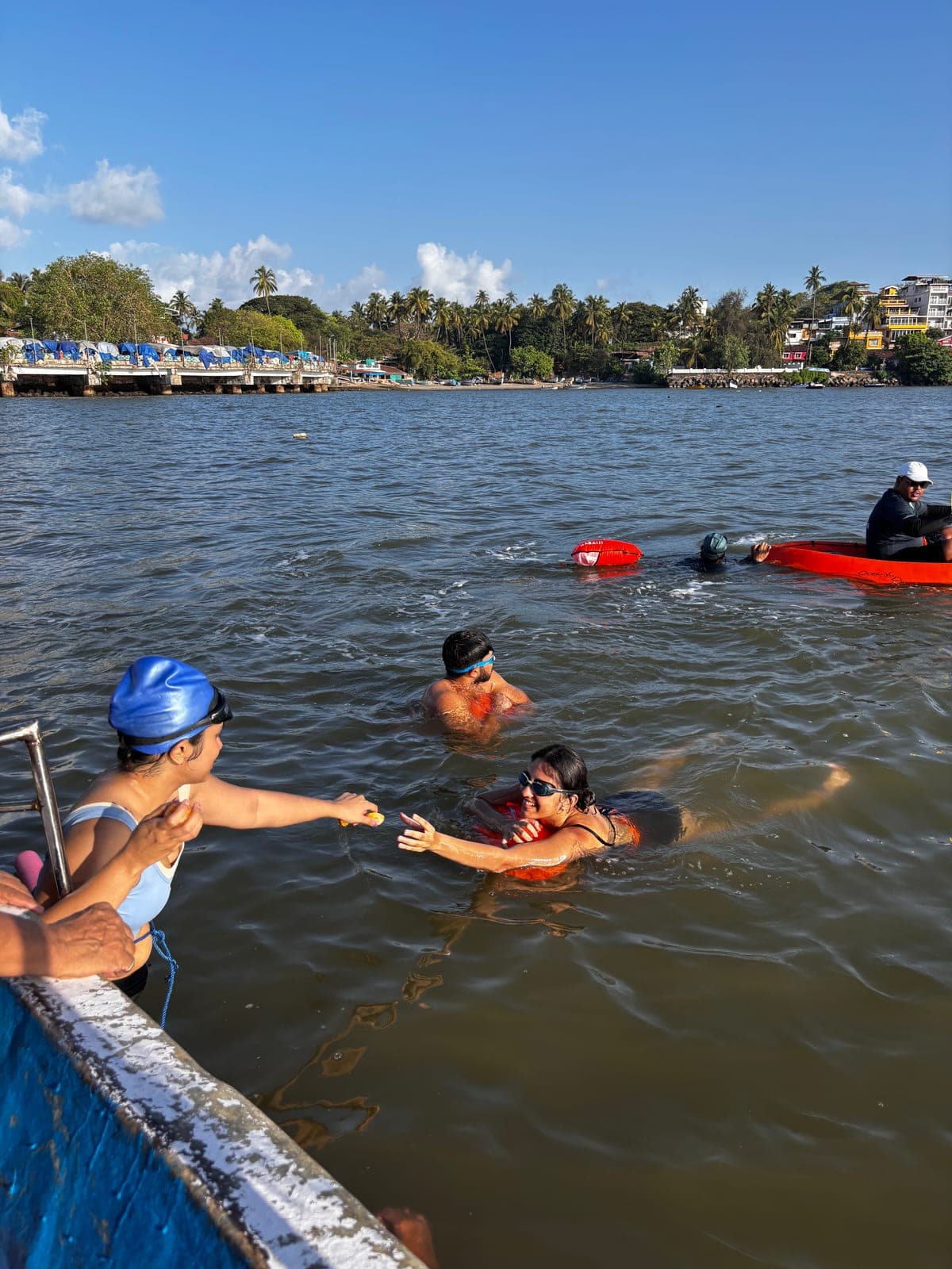 Handing snacks down to swimmers from the boat
