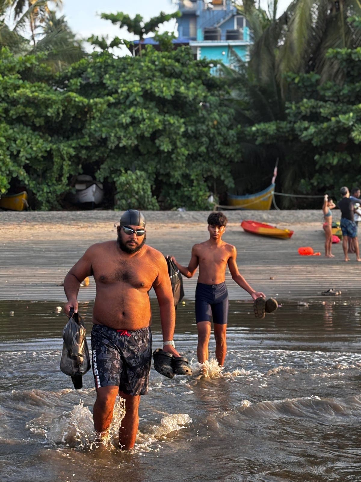 Two swimmers walking out of the water after a morning swim